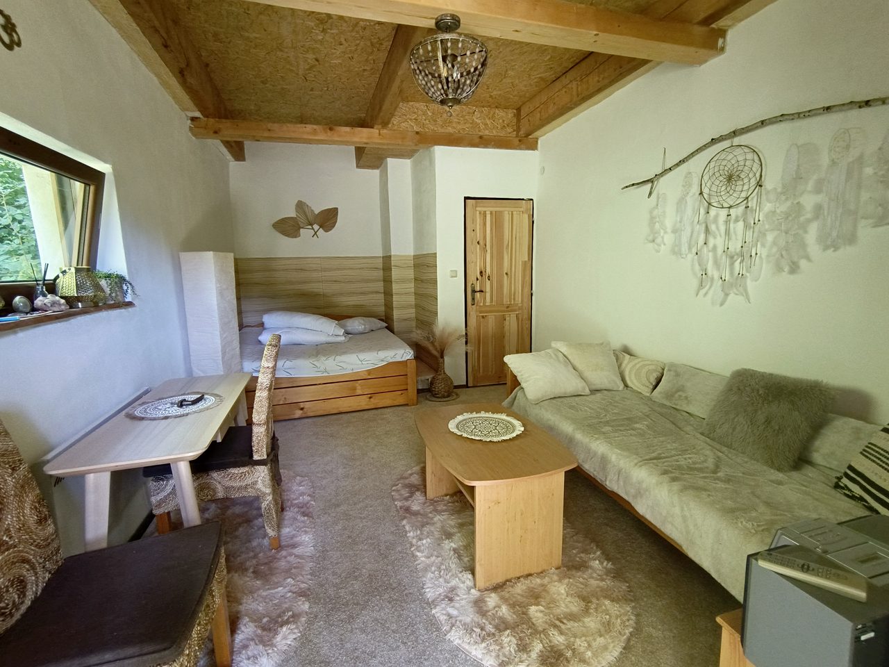 Boho pokoj — dřevěné trámy, lapač snů, útulný přírodní prostor